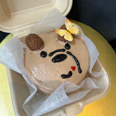 Cupcake with cartoon bear face design in a takeout bento box